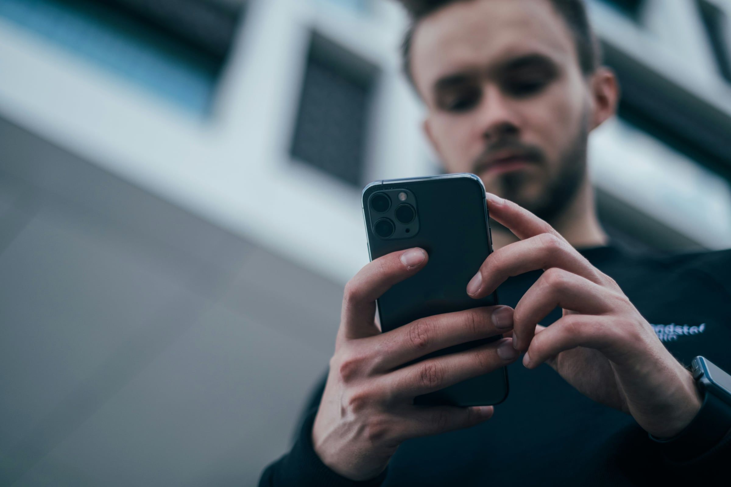 Un homme regarde attentivement l'écran de son smartphone